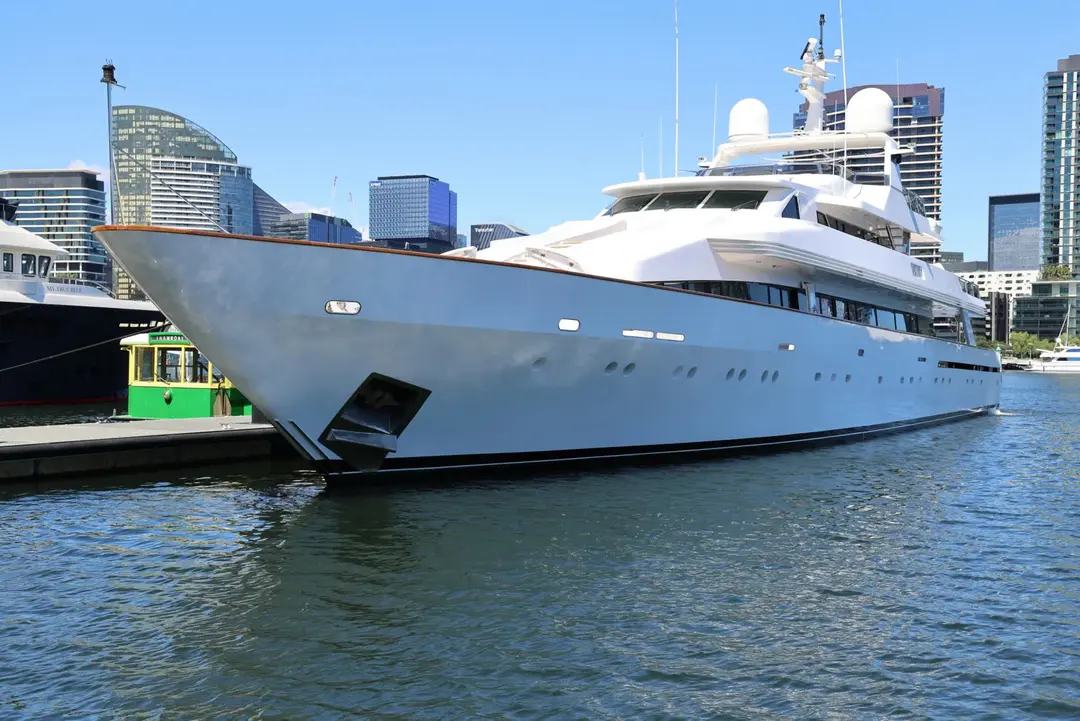 White luxury yacht docked at a modern urban marina