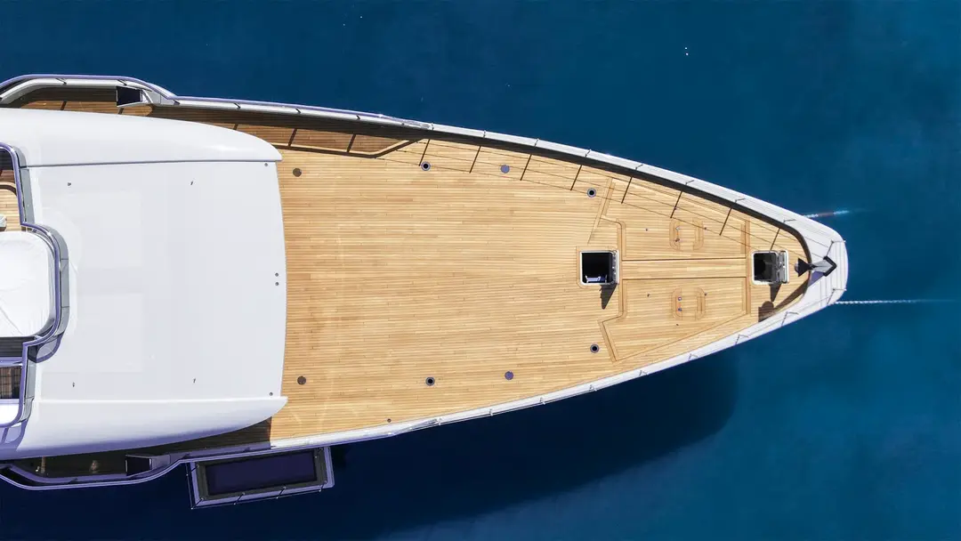 Aerial top-down view of a luxury yacht in vivid blue waters
