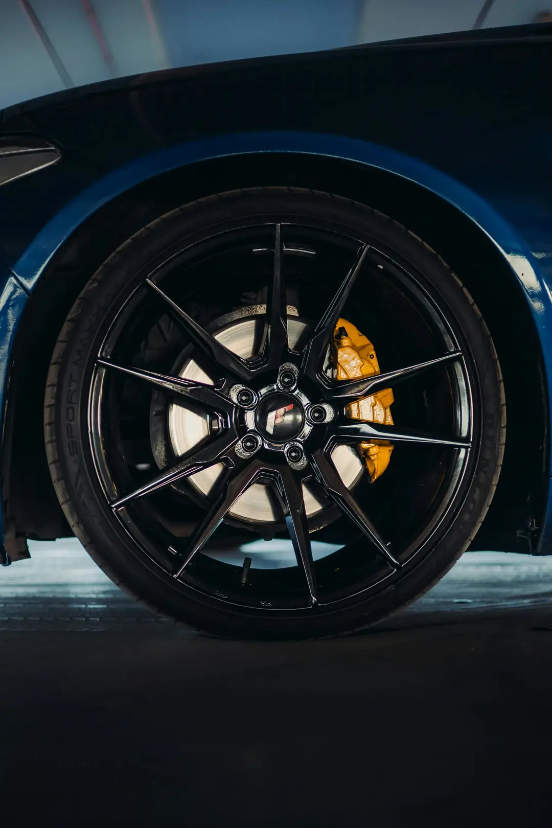 Black multi-spoke alloy wheel with bold yellow performance brake caliper