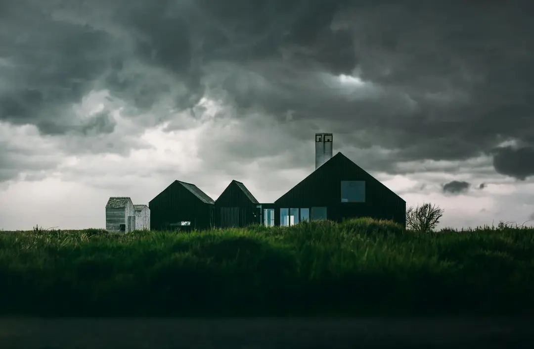 Modern home standing under a vast brooding sky of thick storm clouds
