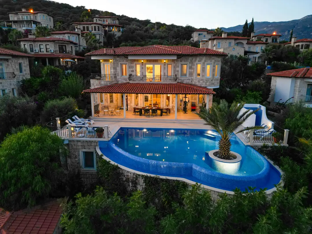 Modern luxury home exterior at twilight with warm interior glow