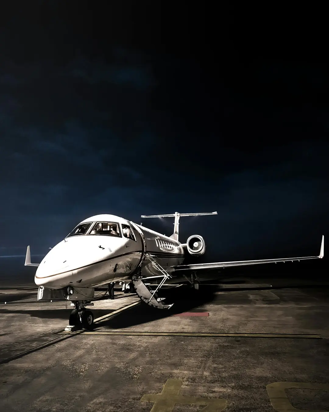 Private jet illuminated on the tarmac at dusk